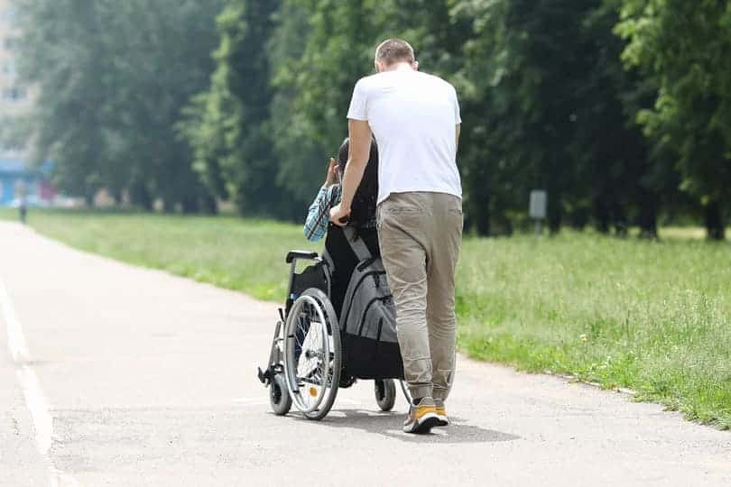 Frau im Rollstuhl wird geschoben