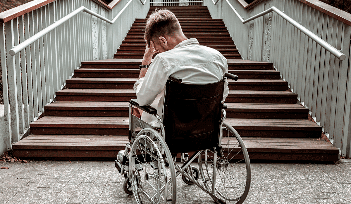 Rollstuhlfahrer hilflos vor einer Treppe