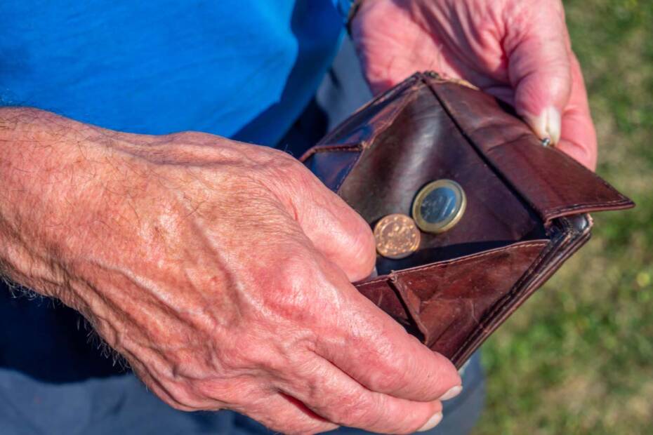 Alter Mann mit Münzen im Portemonnaie