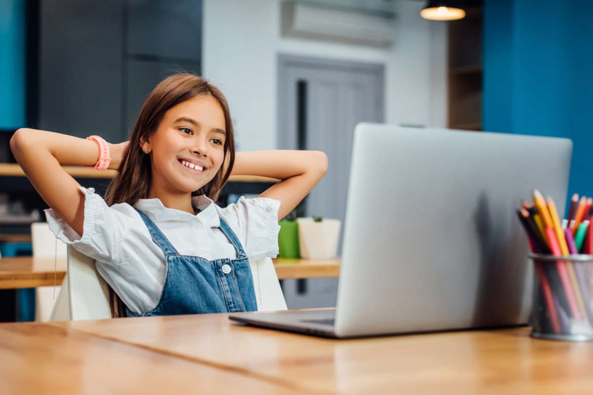 Mädchen istzt glücklich vor einem Laptop
