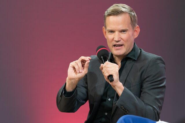 Hendrik Streek, Virologe und CDU-Politiker mit Mikrofon in der Hand