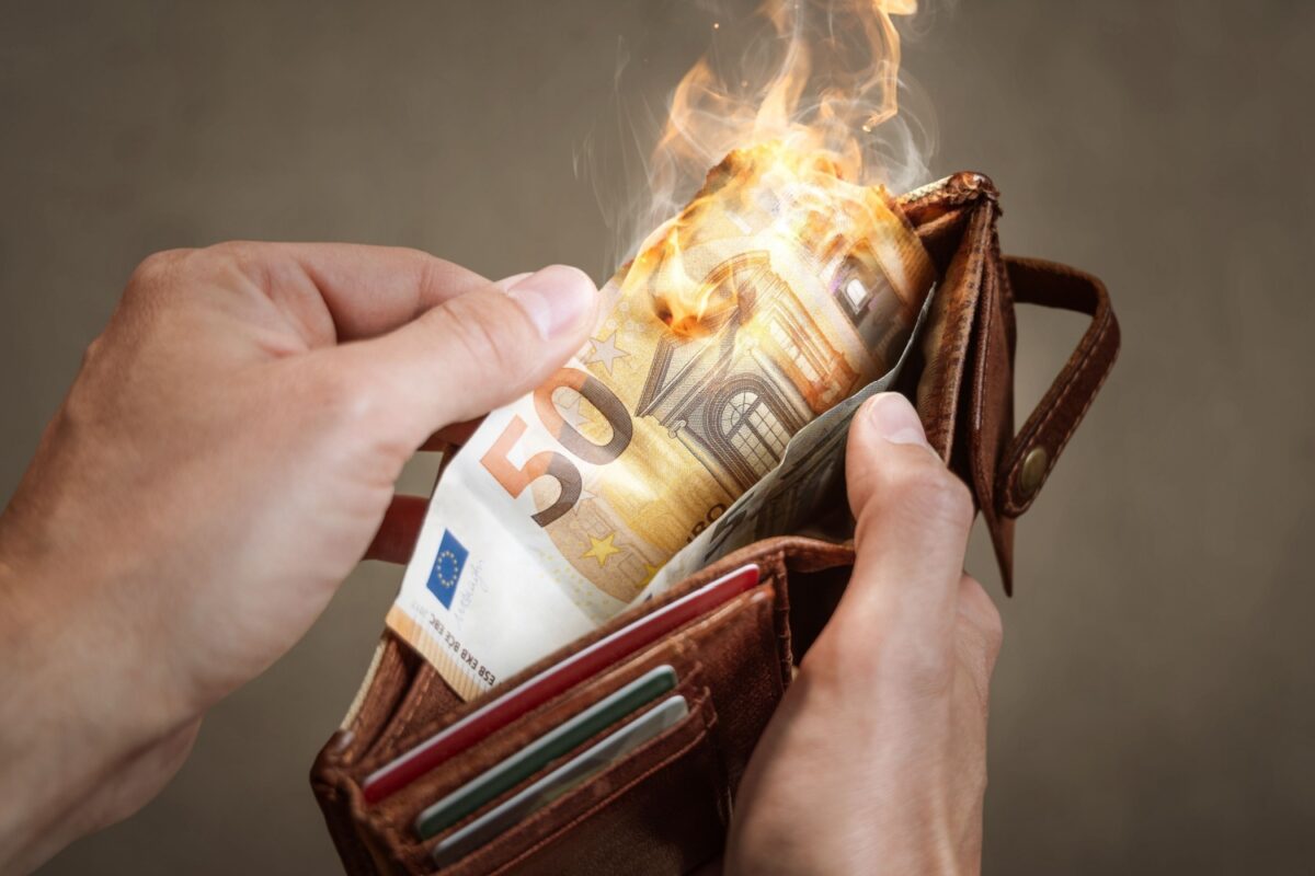 Portemonnaie mit brennendem 50-Euro-Schein, symbolisch für Bürgergeld Nullrunde trotz Inflation