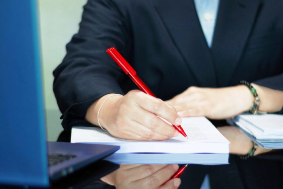 Sachbearbeiter im Amt korrigiert mit rotem Stift Dokumente