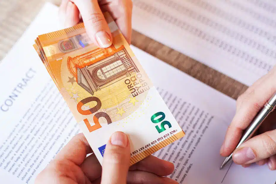 Geld wird überreicht nach Vertragsunterzeichnung, symbolisch für Restschuldversicherung