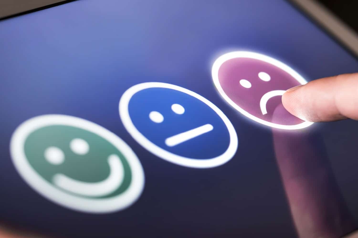 Tablet-Display, auf dem Smileys zum antippen zu sehen sind, symbolisch für Bewertung