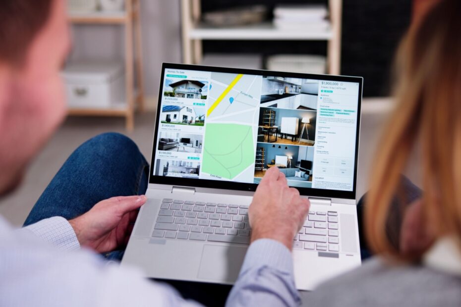 Zwei Personen vergleichen online Wohnungsangebote auf einem Laptop