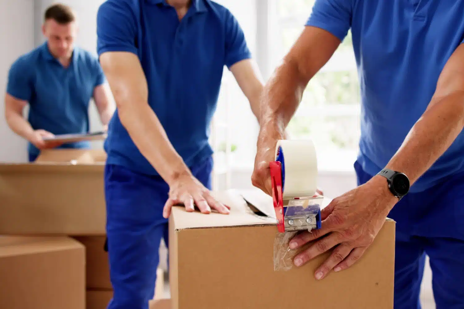 Mitarbeiter eines Umzugsunternehmens packen Kisten, Vorbereitung auf Umzug