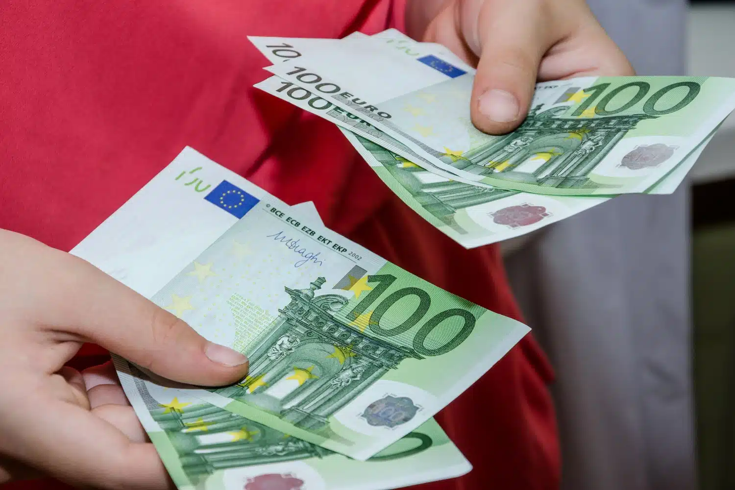 Frau zählt mehrere 100-Euro-Scheine