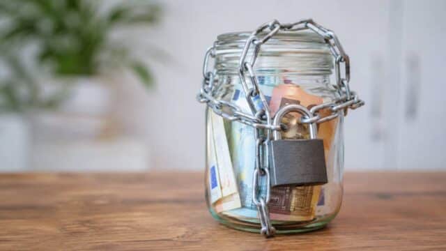 Verschlossenes Sparglas mit Euro-Scheinen als Symbol für gesperrtes Vermögen beim Bürgergeld