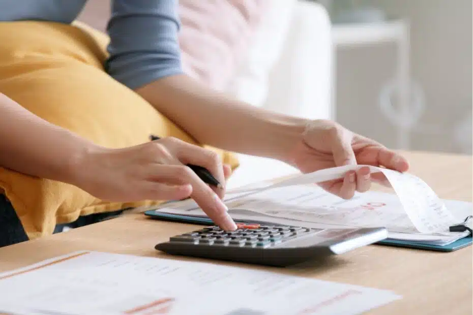 Frau prüft Stromrechnung mit Taschenrechner