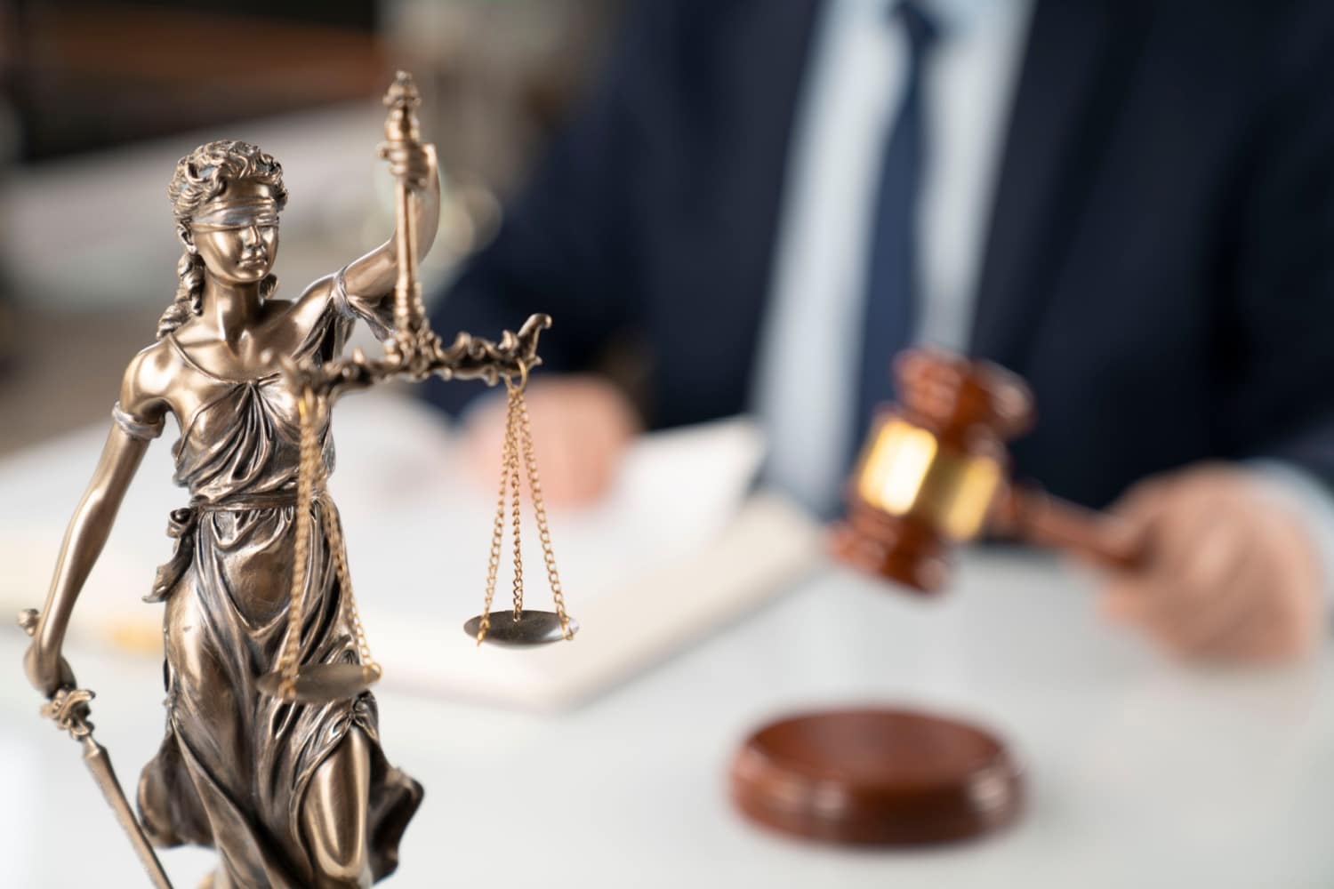 Richter im Amtszimmer mit Hammer und Justitia lehnt Antrag des Jobcenters ab