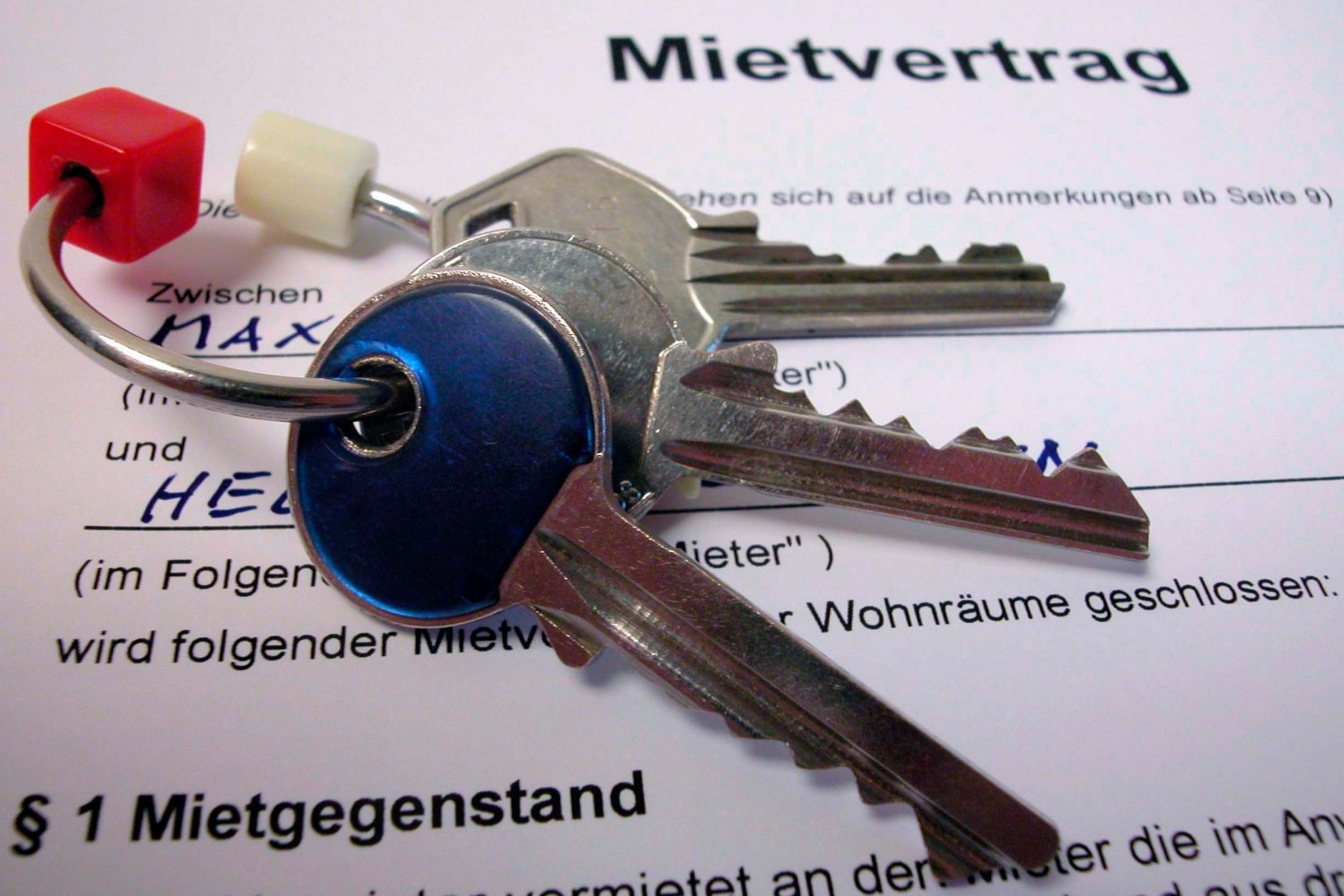 Wohnungsschlüssel liegen auf einem ausgefüllten Mietvertrag