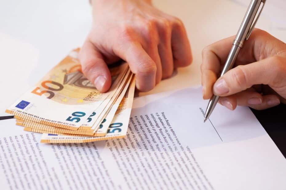 Eine Hand unterschreibt ein Dokument, eine andere Hand hält 50 Euro Scheine hin
