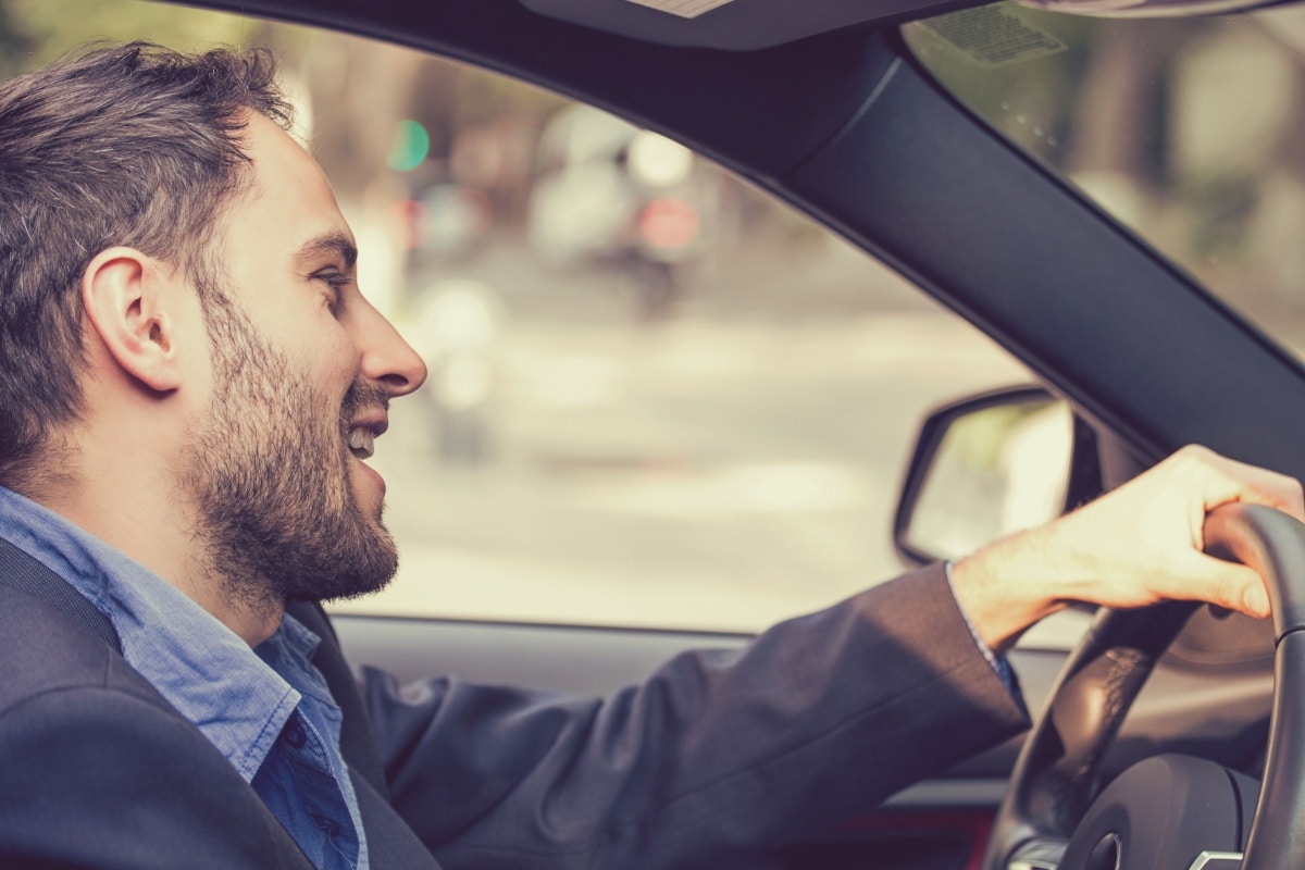 Mann sitzt am Steuer seines Autos