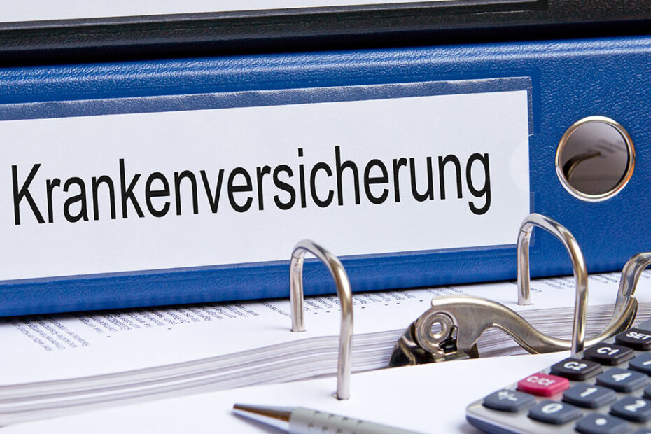 Aktenordner mit Aufschrift Krankenversicherung und Taschenrechner