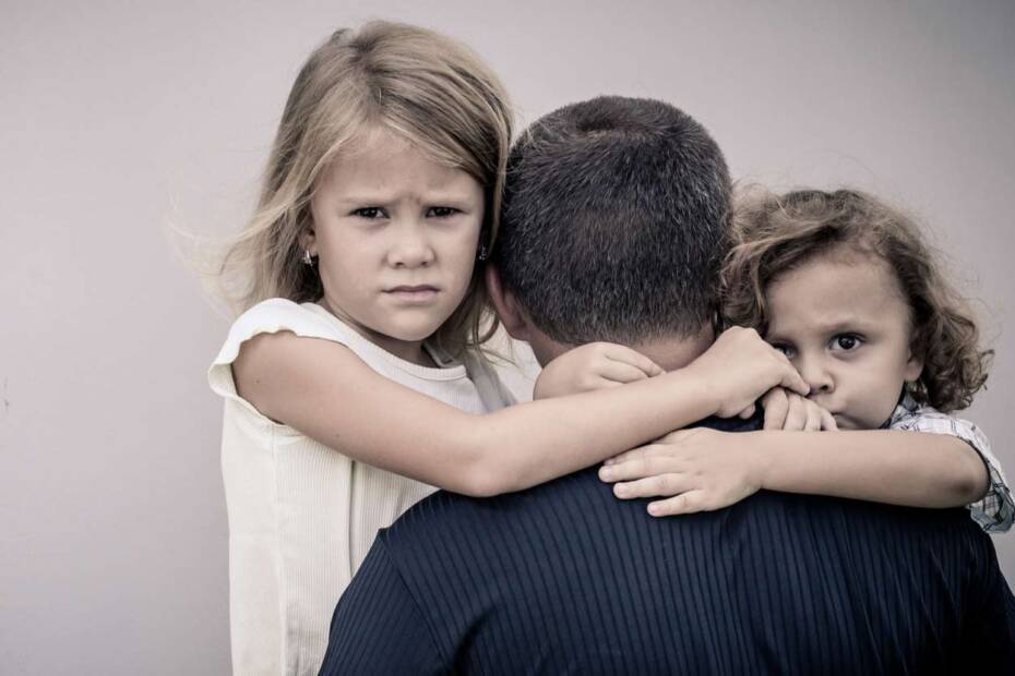 Traurige Kinder umarmen Vater