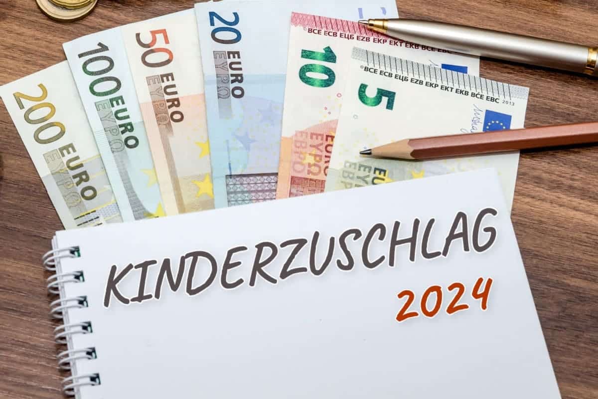 Kinderzuschlag auf Notizblock mit Geld