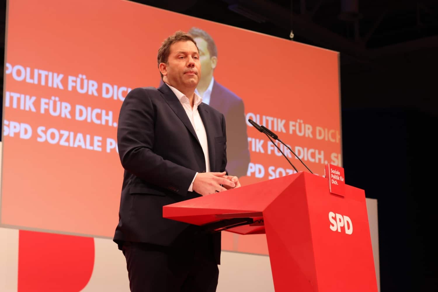 SPD-Politiker Lars Klingbeil am Rednerpult auf einem SPD-Parteitag, vor rotem Hintergrund mit dem Slogan „Soziale Politik für Dich.“