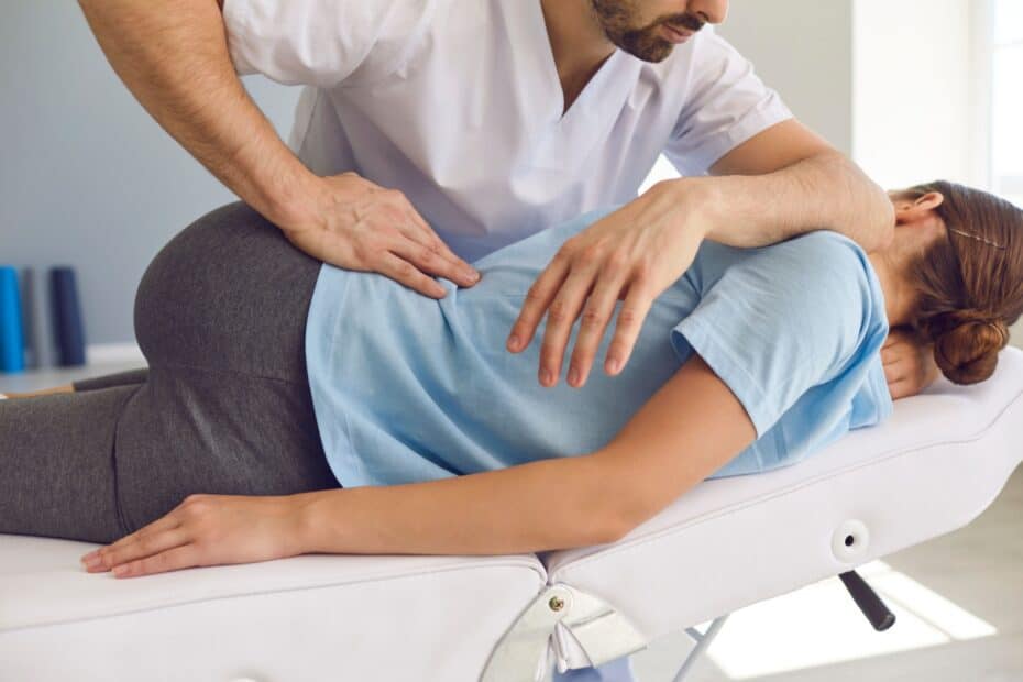 Frau wird auf Liege beim Chiropraktiker behandelt reha
