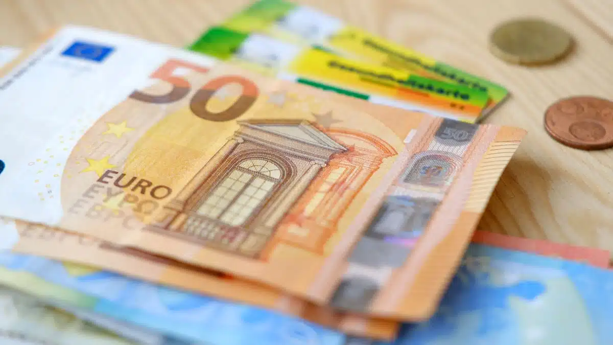 Geldscheine liegen auf Gesundheitskarte, symbolisch für Kostenübernahme der Krankenversicherung