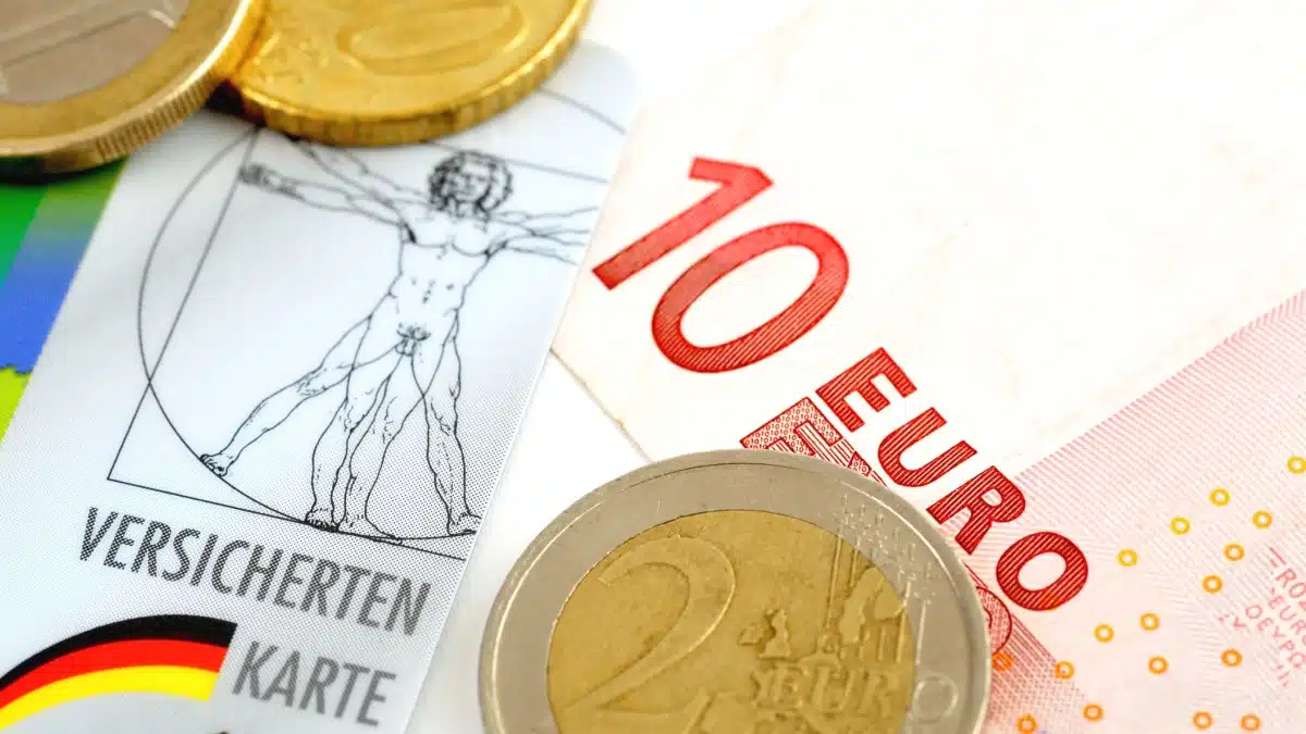 Versichertenkarte und Euro-Scheine. Symbolisiert die Kostenübernahme der Krankenversicherung beim Bürgergeld durch das Jobcenter.