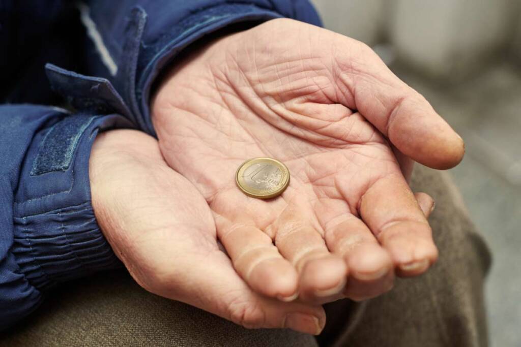 Mann hält 1 Euro in der Hand