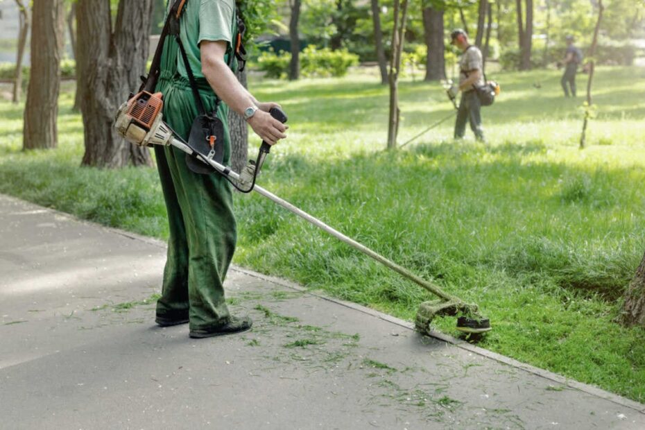 Arbeiter bei der Grünpflege im Park Rasenmähen