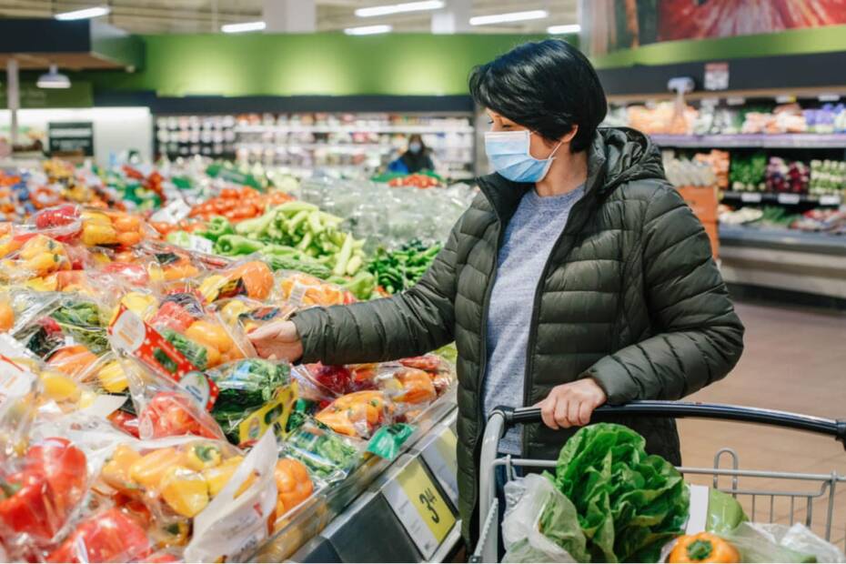 Frau in der Gemüseabteilung eines Supermarktes