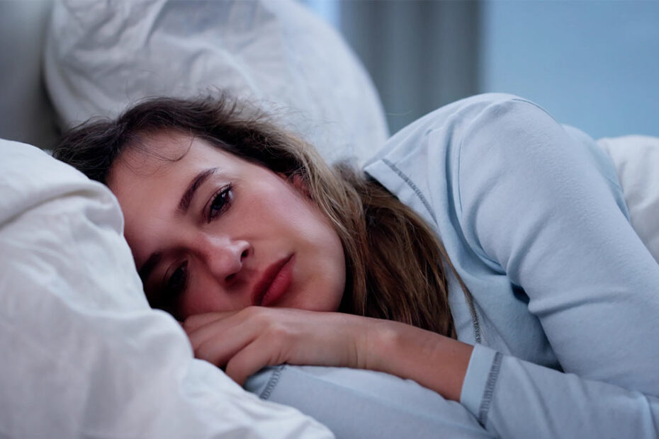 Frau mit psychischer Erkrankung liegt im Bett