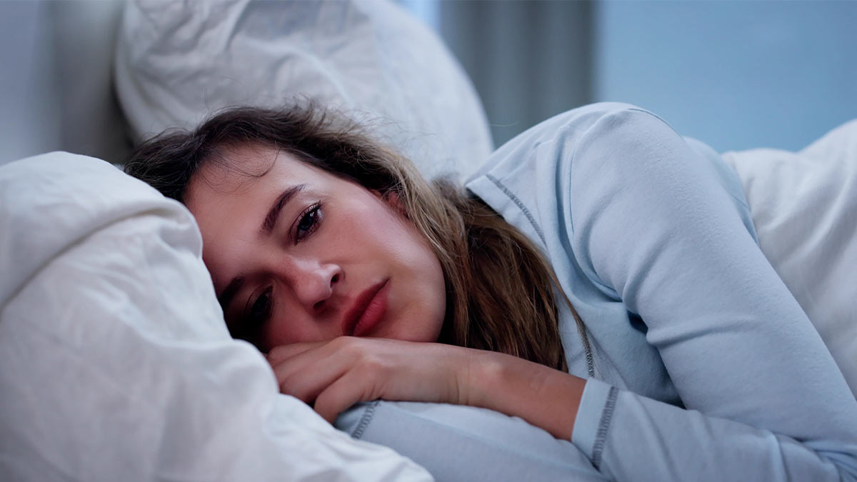 Frau mit psychischer Erkrankung liegt im Bett