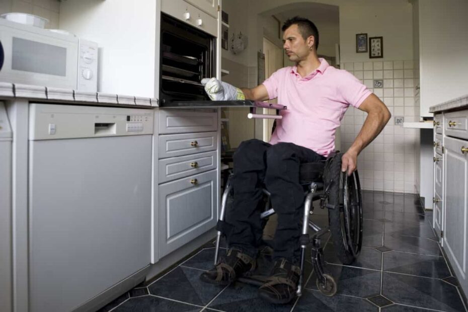 Mann im Rollstuhl in seiner Küche