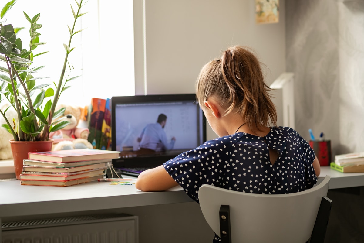 Mädchen sitzt vor Notebook beim Homeschooling