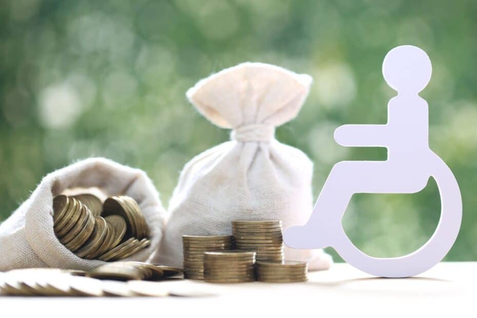 Rollstuhl-Figur neben Säckchen mit Münzen, symbolisch für Zuschuss bei Behinderung
