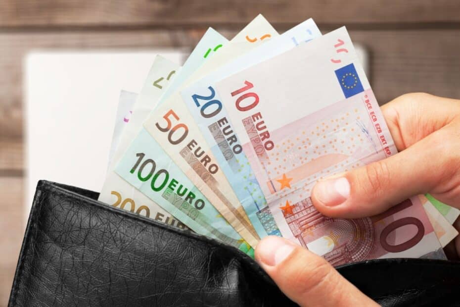 Hände holen Geldscheine aus Geldbörse