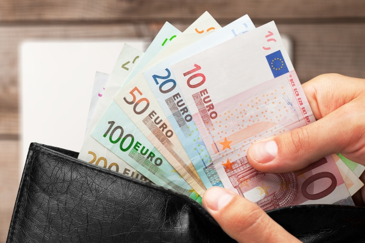 Hände holen Geldscheine aus Geldbörse