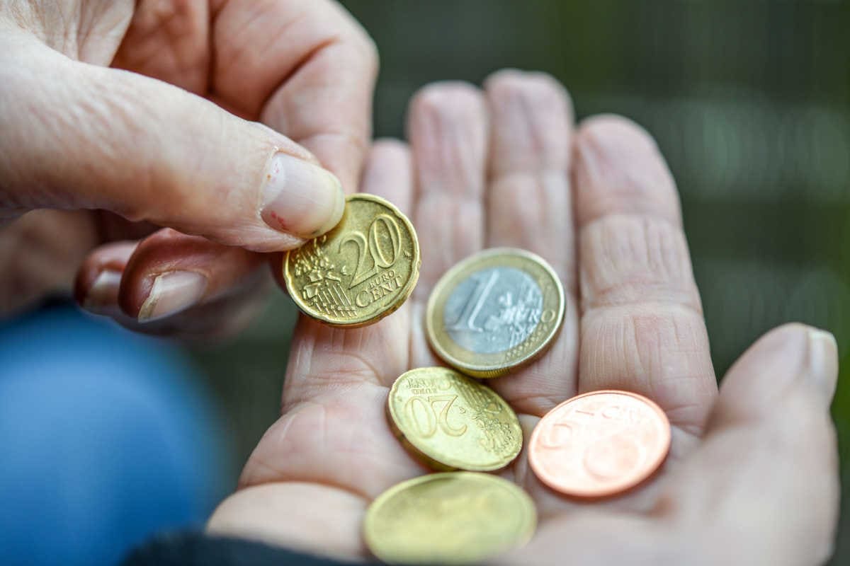 Hände mit wenig Euro Kleingeld als Symbol für Armut