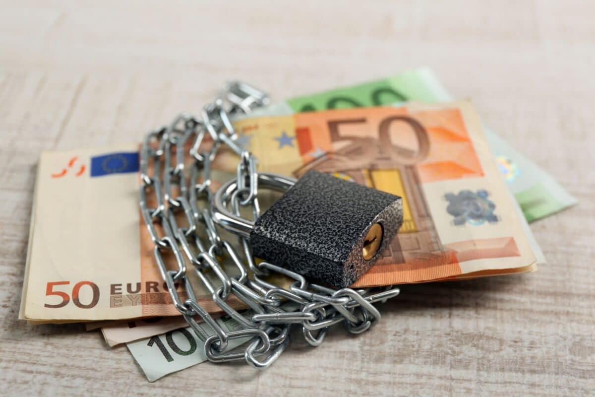 Euro-Banknoten mit Ketten und Schloss gesichert, symbolisch für Pfändungsfreibetrag