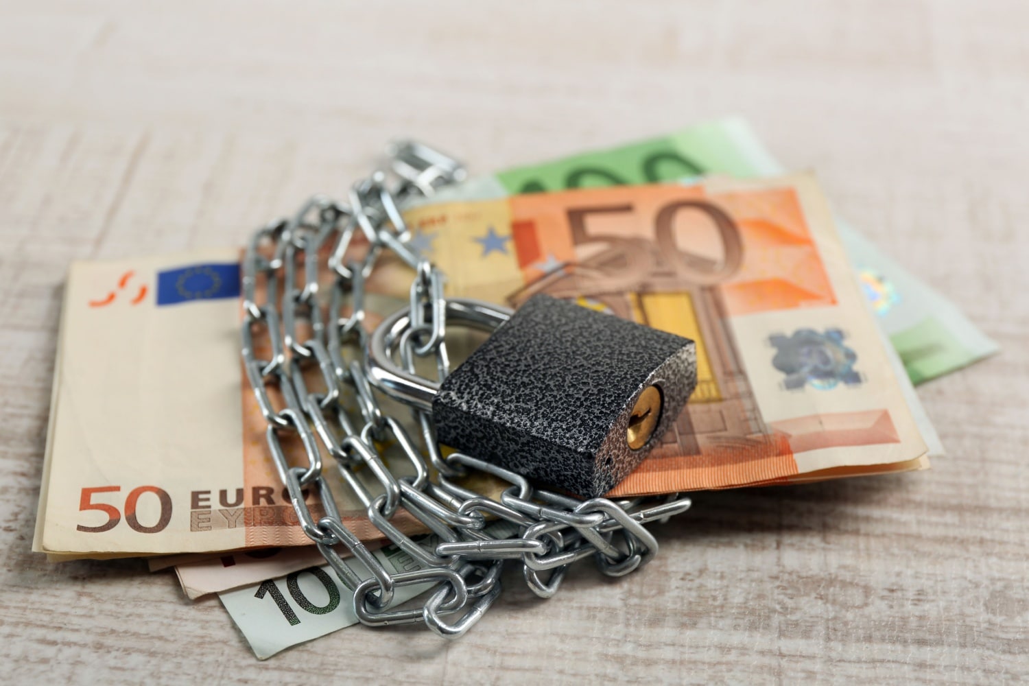 Euro-Banknoten mit Ketten und Schloss gesichert, symbolisch für Pfändungsfreibetrag