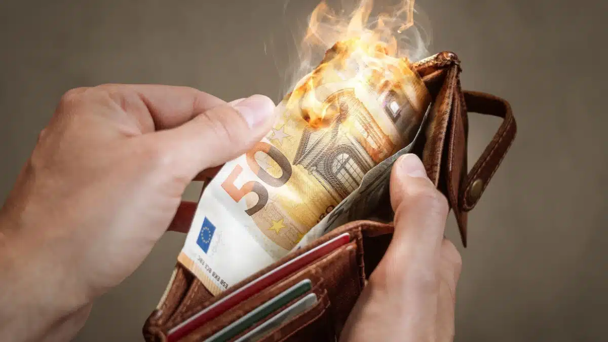 Brennender 50-Euro-Geldschein in der Geldbörse, symbolisch für die Entwertung des Bürgergeld-Regelsatzes durch Inflation