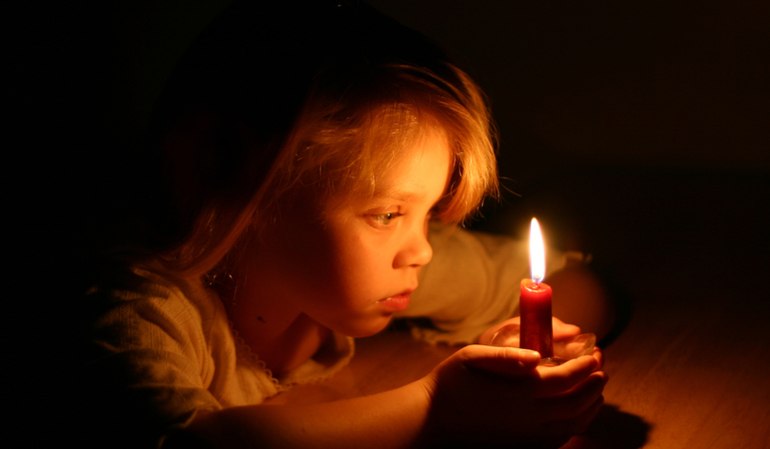 Kleines Mädchen mit einer Kerze