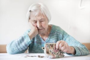 Traurige alte Frau in Geldnot