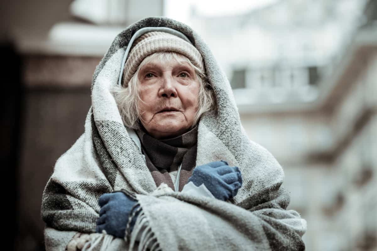 obdachlose Rentnerin in Decke gehüllt