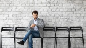 Mann sitzt allein und wartet auf den Termin zum Vorstellungsgespräch