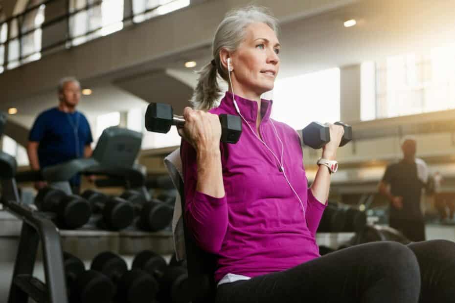 ältere Frau trainiert im Fitnessstudio mit Hanteln