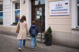 Mutter mit Kind vor einer russischen Sprachschule auf dem Weg zum Unterricht