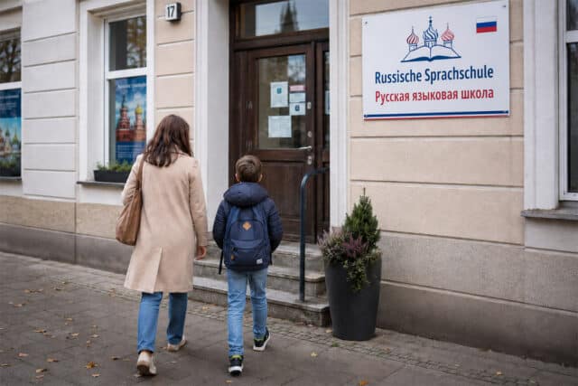 Mutter mit Kind vor einer russischen Sprachschule auf dem Weg zum Unterricht
