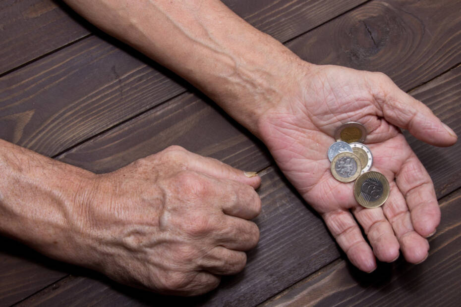 Ältere Hand hält Münzen