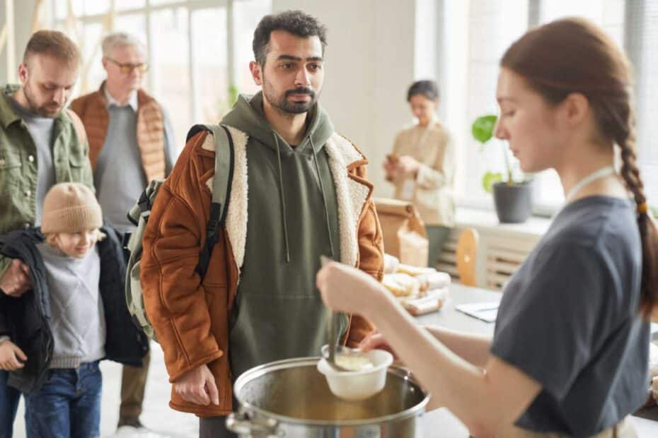 Menschen stehen in der Suppenküche an