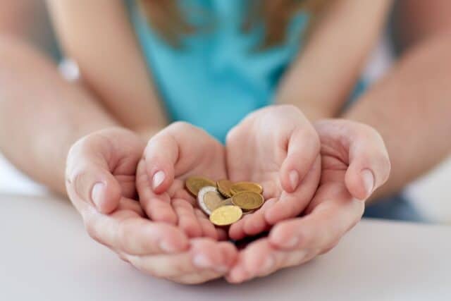 Hände zählen Euro-Münzen als Symbol für drohende Unterhaltsvorschuss-Kürzungen und die finanzielle Belastung von Alleinerziehenden.