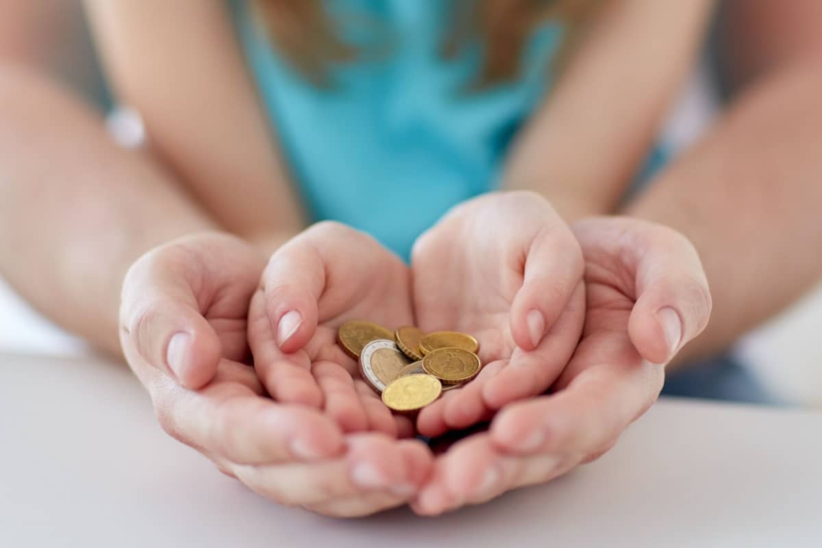 Hände zählen Euro-Münzen als Symbol für drohende Unterhaltsvorschuss-Kürzungen und die finanzielle Belastung von Alleinerziehenden.